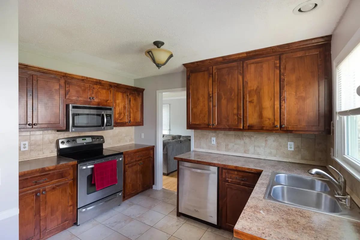 Warm wood-cabinet kitchen with stainless appliances, MLS-ready interior photo