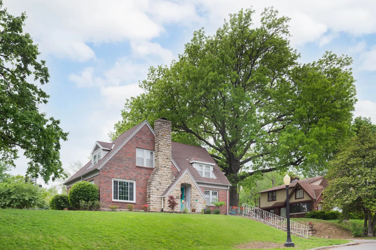 Two-story brick home with a covered front porch, Kansas City metro listing
