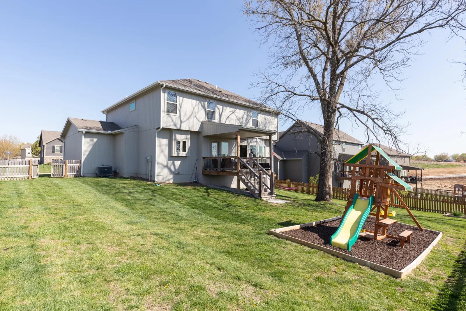 Backyard pool and pergola beside a brick home, Kansas City listing