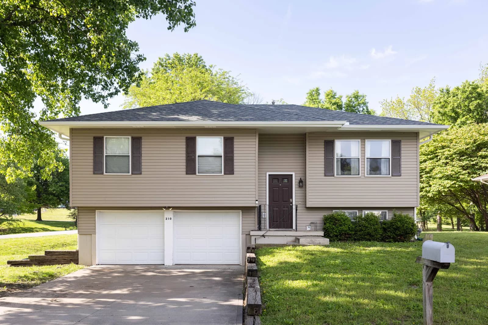 White cottage with a covered porch and black shutters, Kansas City metro listing