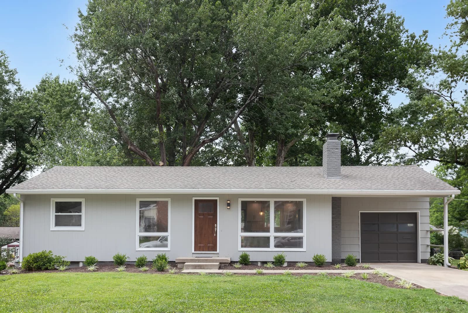 Covered front porch with white railings and columns, Kansas City metro listing