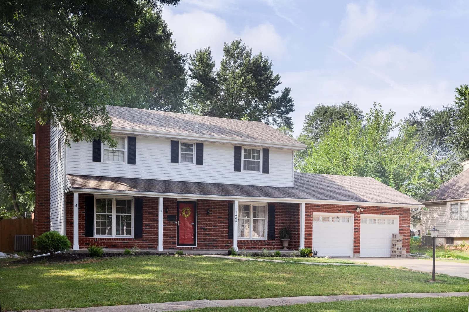 Two-story brick home with white trim, Kansas City metro listing